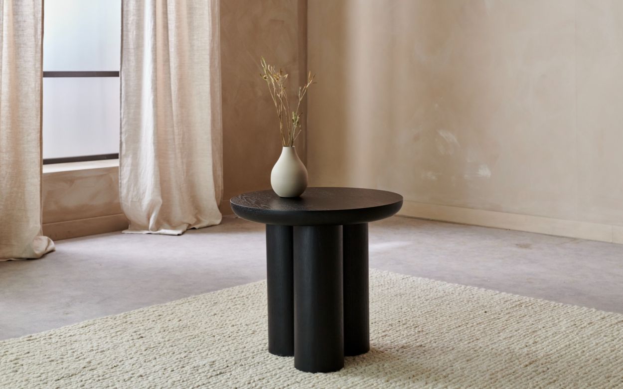 Minimal siyah yuvarlak tasarımlı yan sehpa modelleri şık salon dekorunda yer alıyor