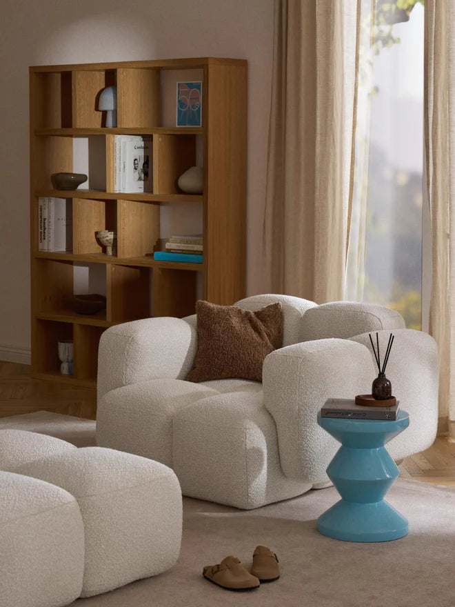 Mobilya Koltuk beyaz yumuşak kumaşlı modern tekli koltuk ve yanında mavi sehpa ile dekoratif salon düzeni