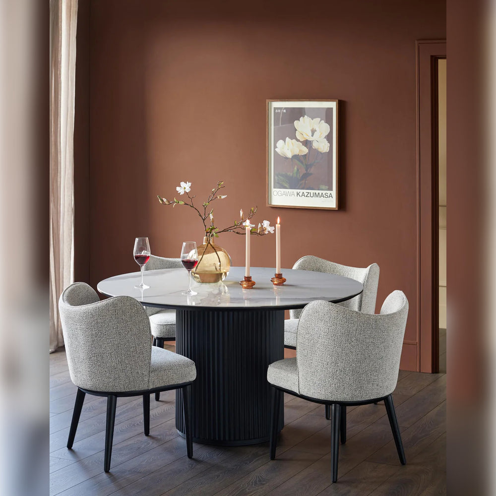 Yuvarlak tasarımlı minimalist beyaz masa etrafında gri kumaşlı dört sandalye bulunan modern yemek odası takımı